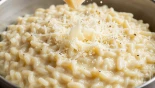 Parmezaanse kaas door risotto roeren