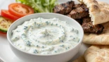 Tzatziki saus wordt geserveerd met gegrild vlees en pita.