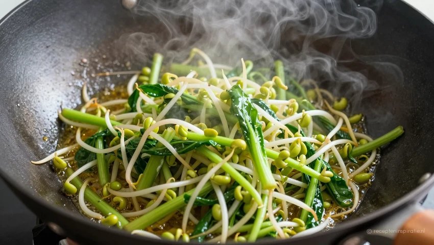Paksoi en taugé worden roergebakken in een wok.
